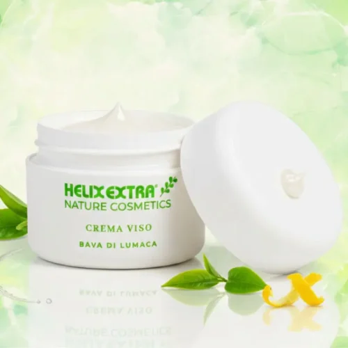 "Dettaglio texture della Crema Viso alla Bava di Lumaca Helix Extra con ingredienti naturali e fiori su sfondo verde"